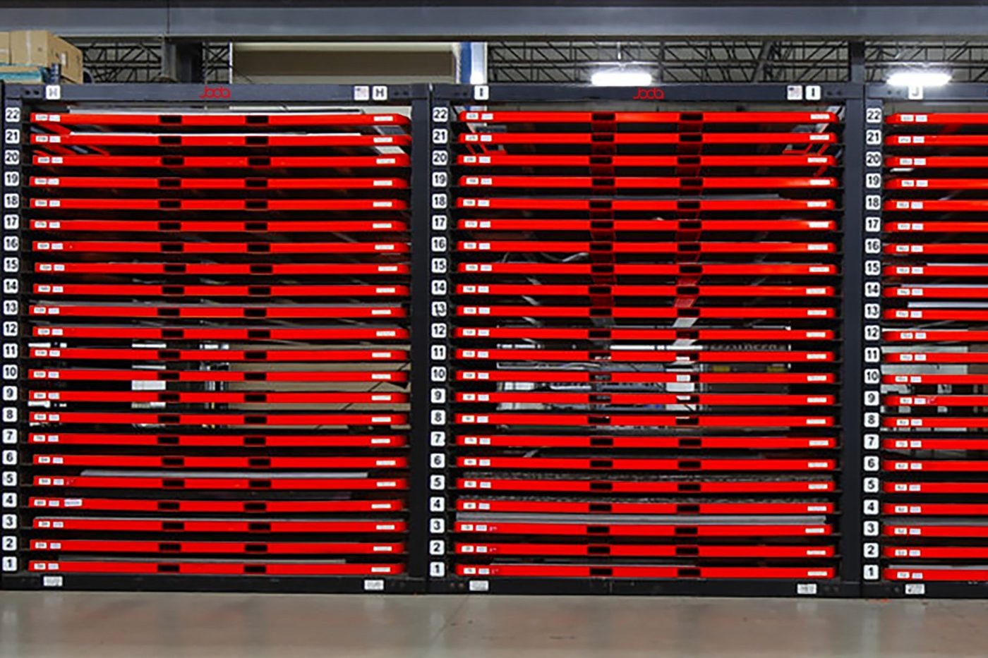 Three JODA P-RACK 510x22 towers on a fabrication shop floor, each column numbered 1 to 22